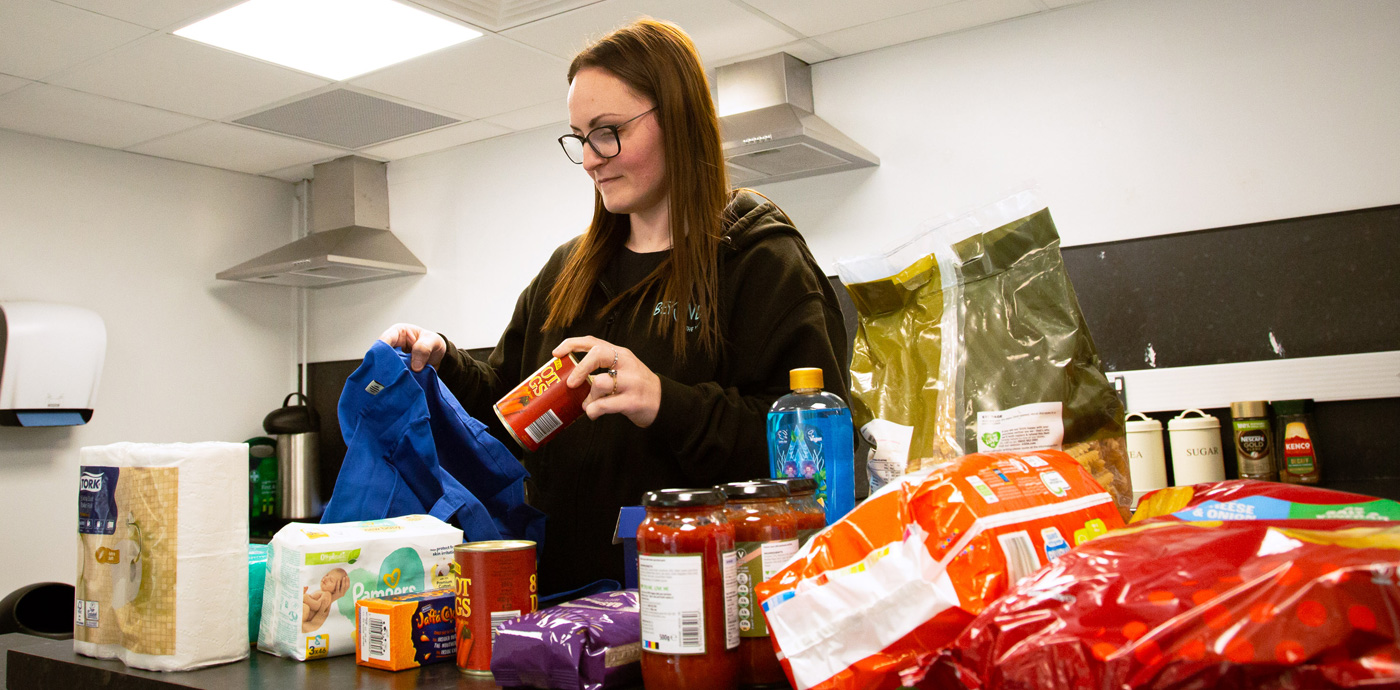 A beyond the margin team member packing a bag with food and toiletries