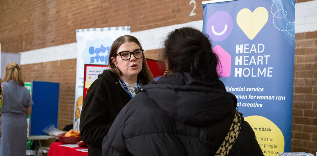 A n image of two women speaking at a community event